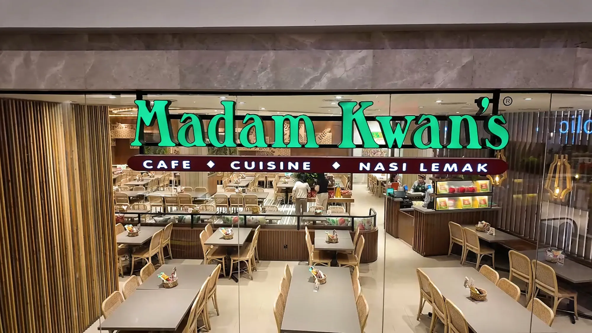 The Madam Kwan's storefront with its green neon sign, Cafe, Cuisine, Nasi Lemak, on Level 1 of Pavilion Kuala Lumpur.