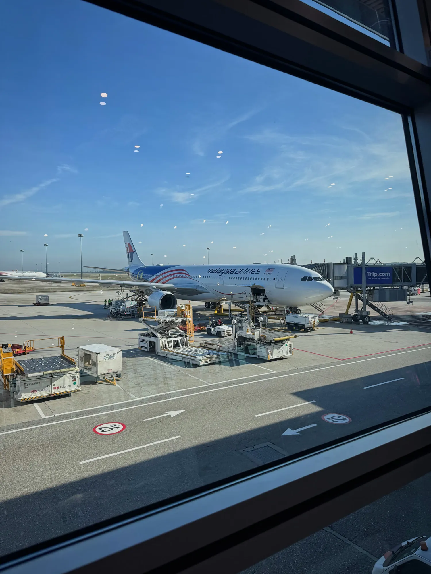 A Malaysia Airlines plane parked outside the terminal window at Kuala Lumpur International Airport.