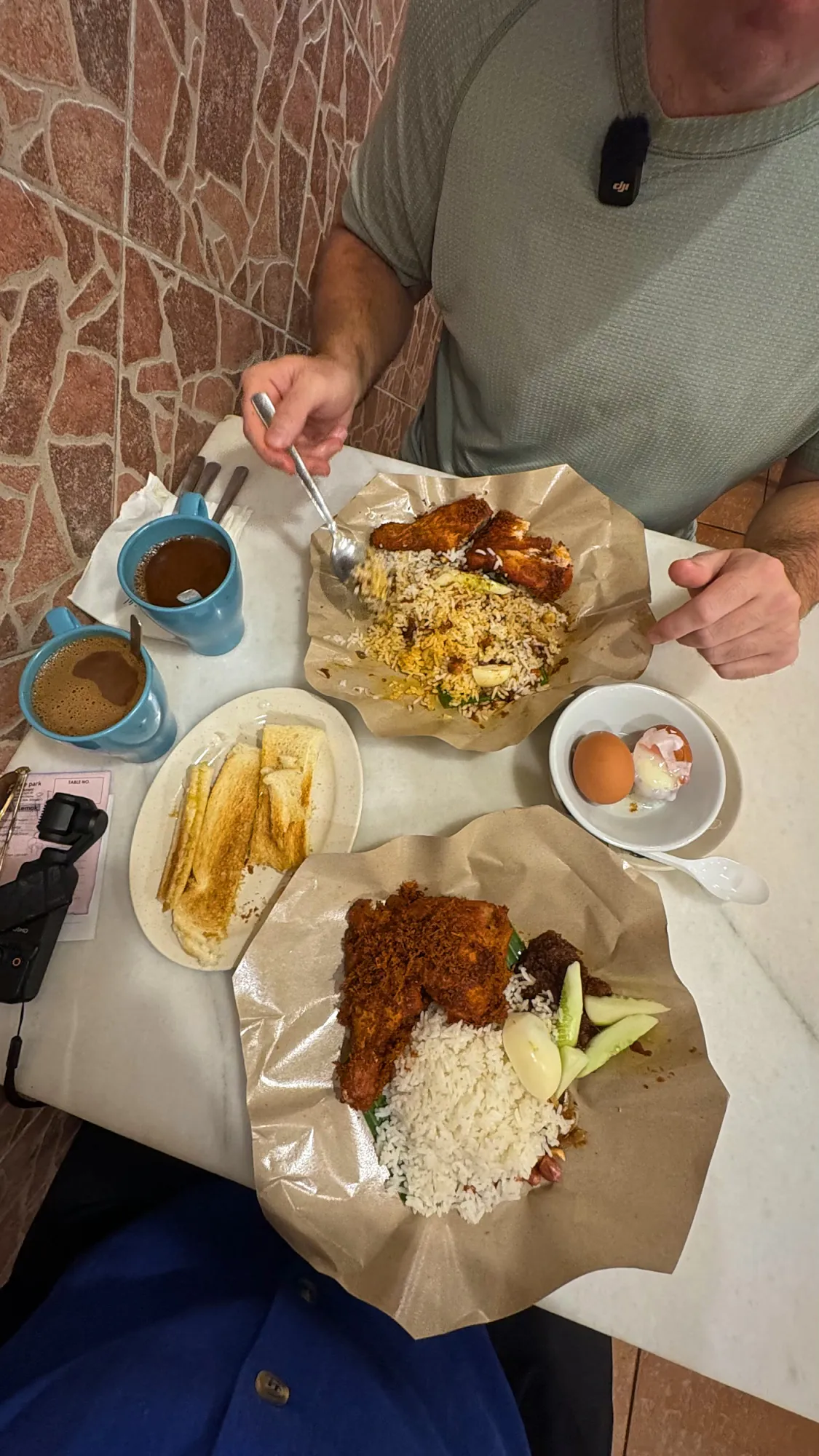Cream at the table at Village Park with nasi lemak, kaya butter toast, soft-boiled eggs, and white coffee.