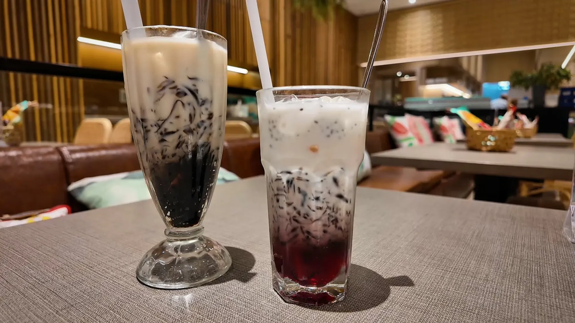 A Black and White with grass jelly and an unmixed sirap bandung in tall glasses on the table at Madam Kwan's.