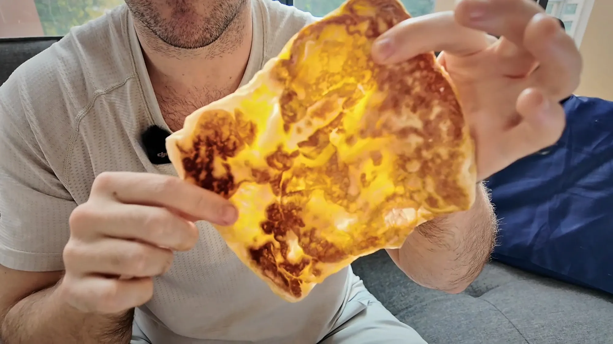 Cream holding up a whole roti telur, golden and blistered, with the egg cooked through the flatbread