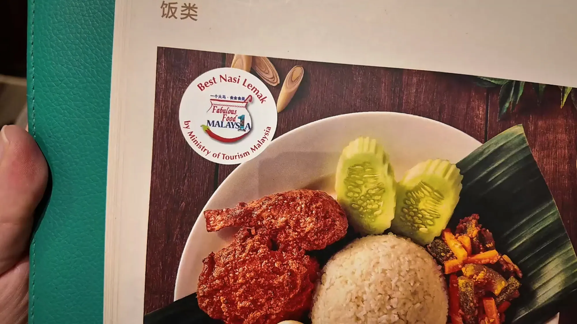 A Madam Kwan's menu page showing nasi lemak with a round Best Nasi Lemak badge from Fabulous Food 1Malaysia by the Ministry of Tourism Malaysia.