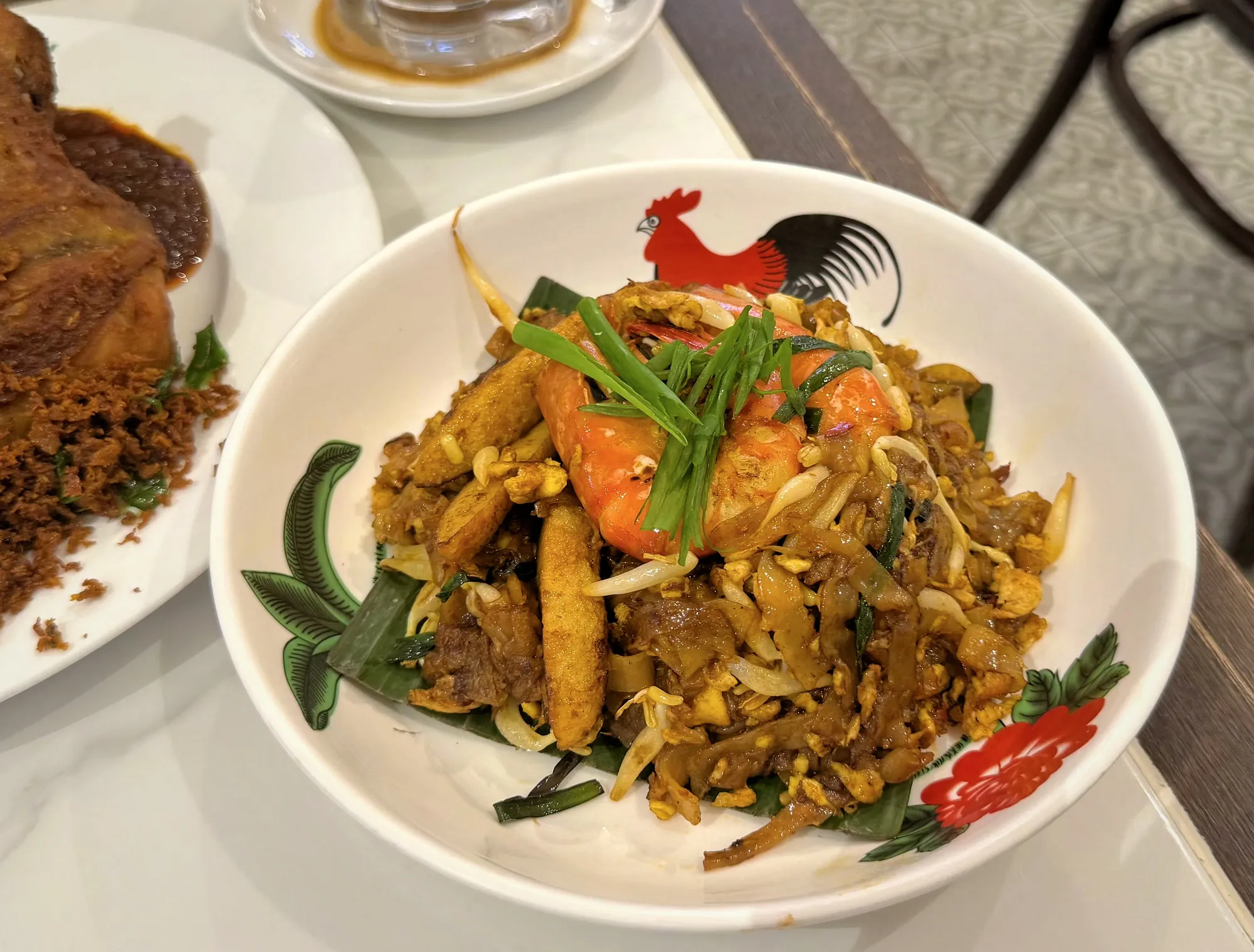 Char kuey teow with prawns and chives in a rooster bowl at Oriental Kopi in Kuala Lumpur.