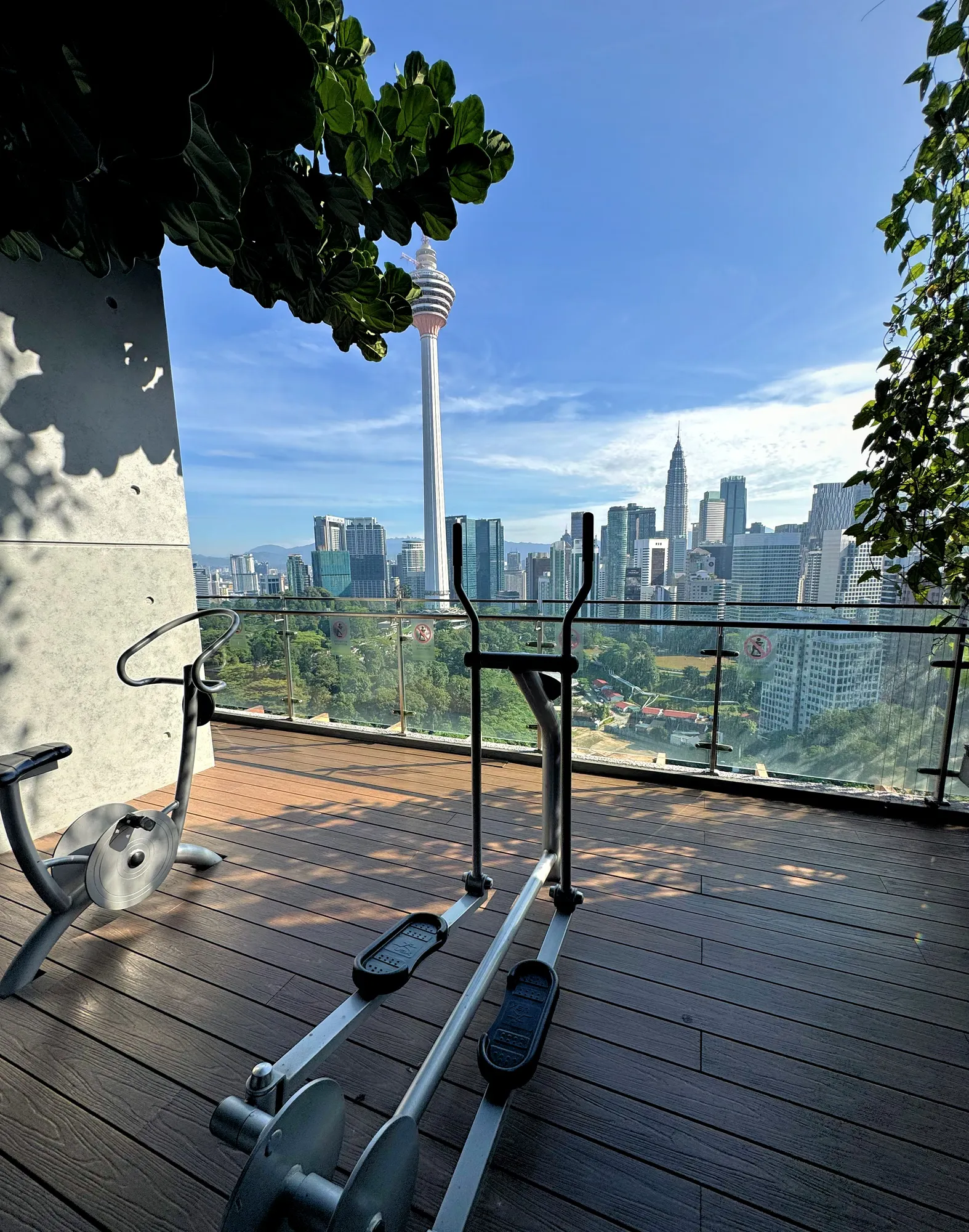 An outdoor elliptical trainer facing the KL Tower and the Kuala Lumpur skyline at Ceylonz Suites.