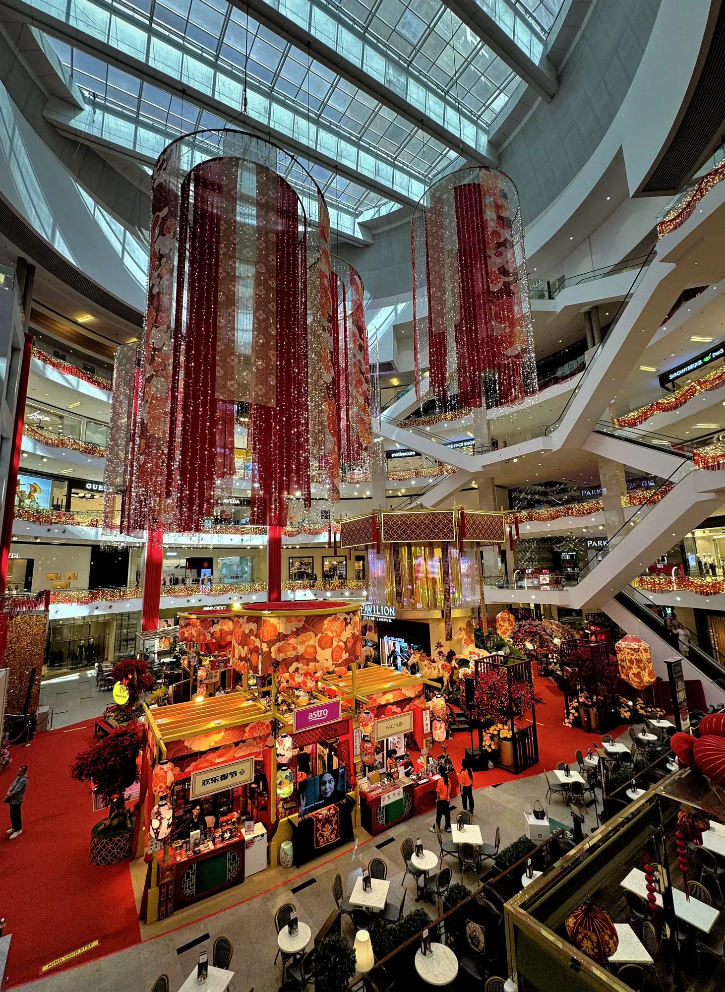 Red and gold Chinese New Year lanterns hanging from the skylit atrium of Pavilion Kuala Lumpur