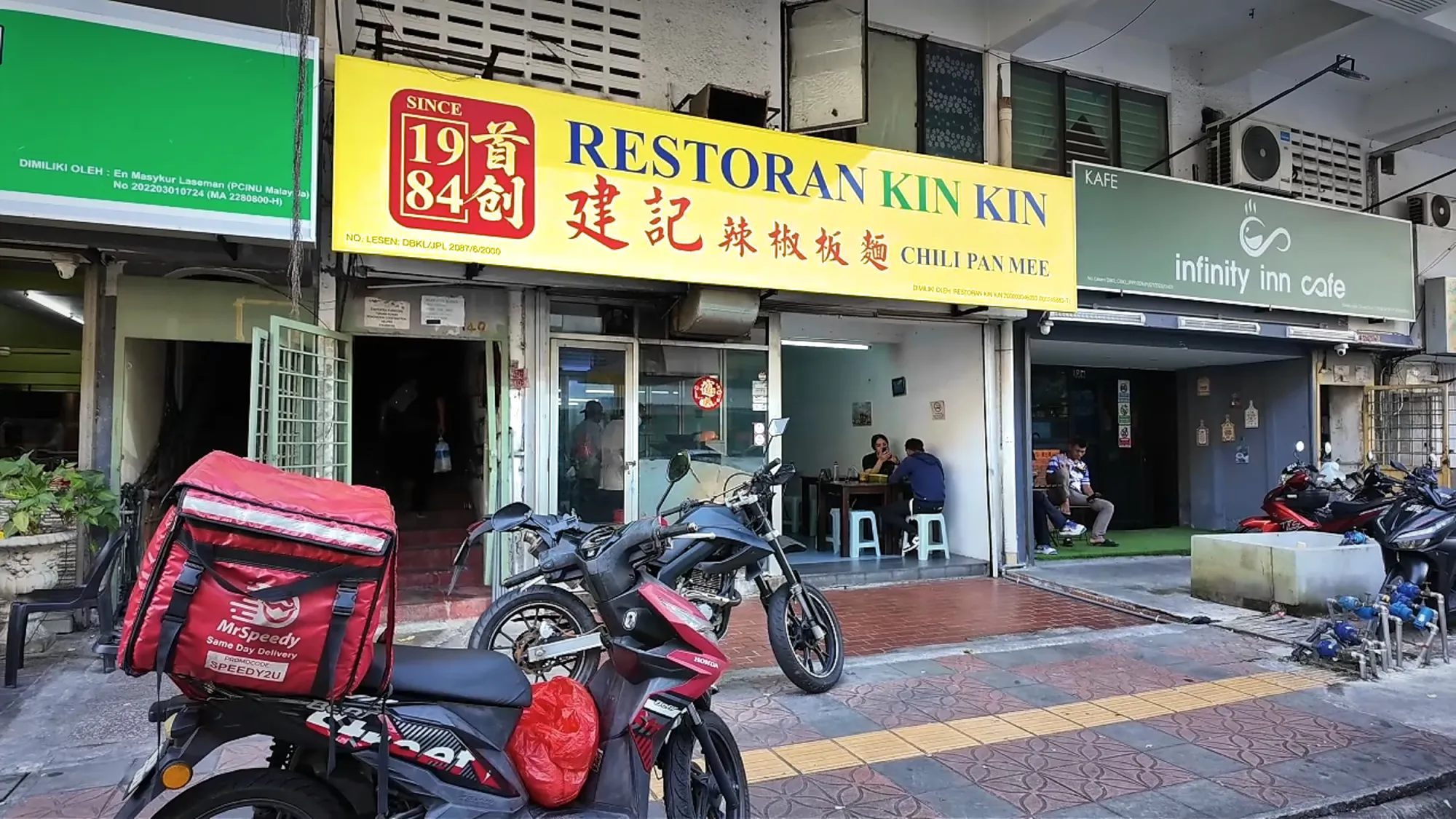 The yellow Restoran Kin Kin sign over the old shophouse noodle shop in Chow Kit, Kuala Lumpur