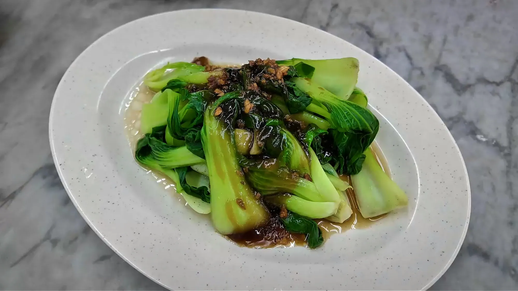 A plate of bok choy with oyster sauce and fried garlic at 168 Claypot Chicken Rice in Pudu, Kuala Lumpur.