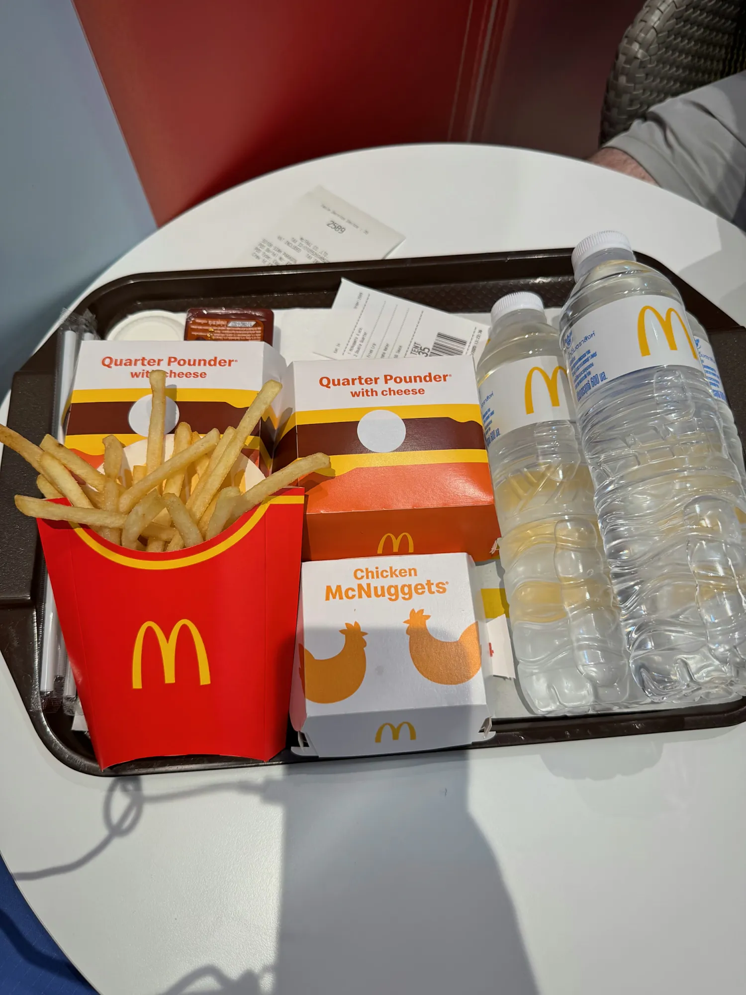 A Quarter Pounder with Cheese, fries, and Chicken McNuggets on a tray at McDonald's in Bangkok, Thailand.