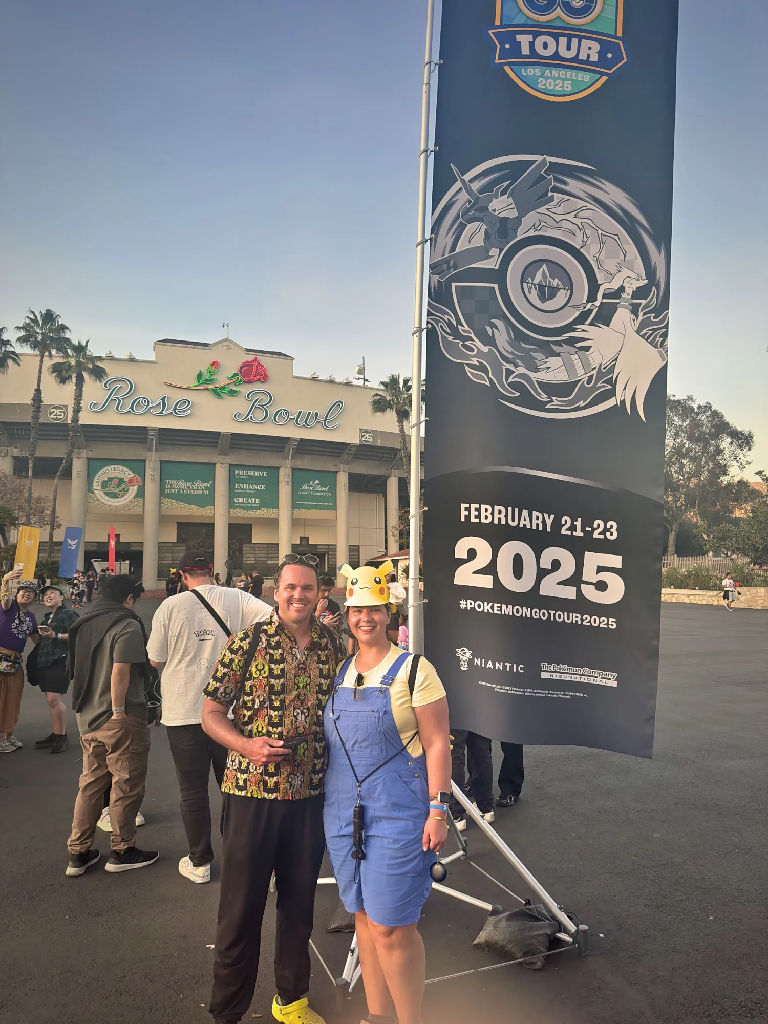 Bernie in a Pikachu hat and overalls with Cream outside Rose Bowl Stadium, next to a GO Tour banner for February 21 to 23, 2025.