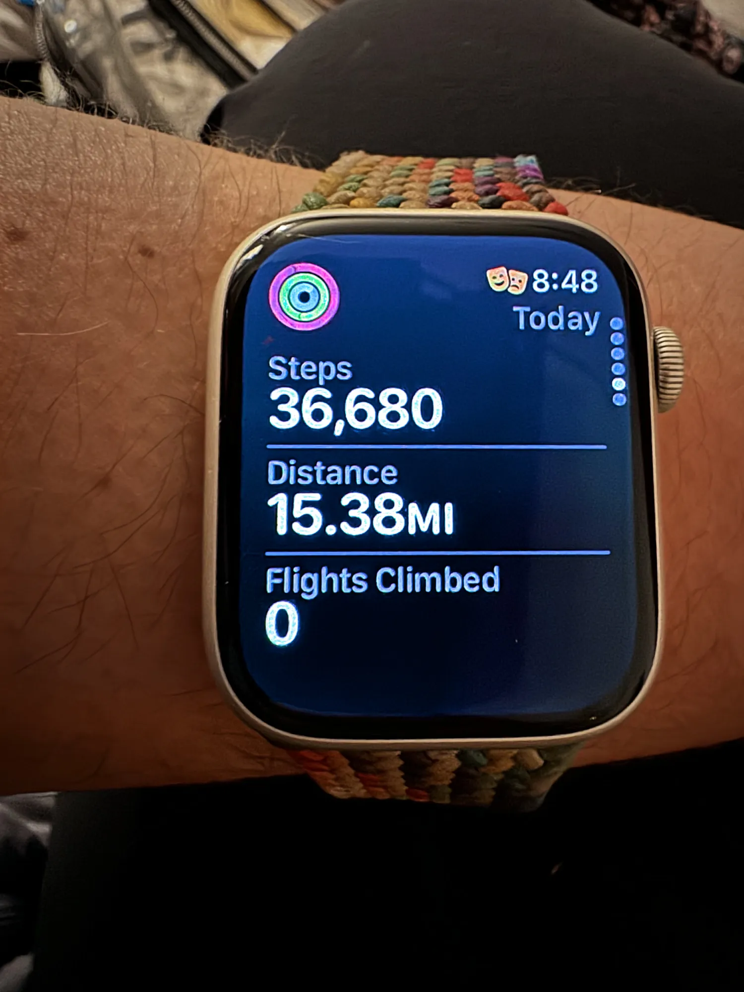 A smartwatch on a wrist showing 36,680 steps and 15.38 miles walked in one day.