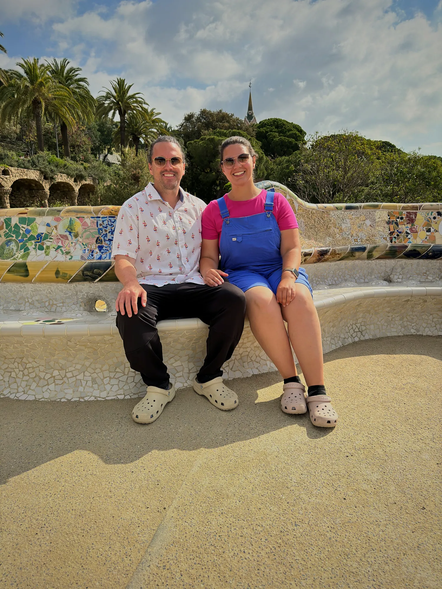 Bernie and Cream smiling together on the mosaic bench at Park Güell in Barcelona